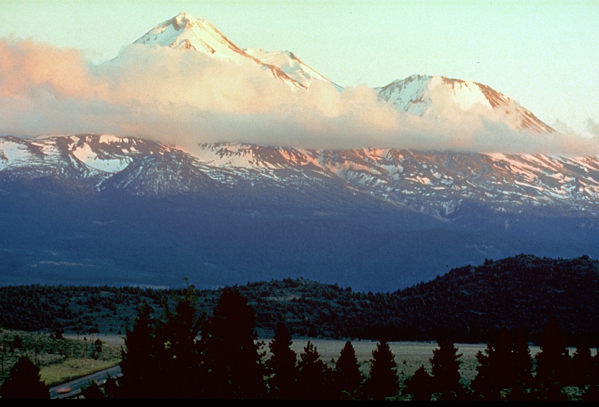 Mount Shasta at sunset along the Volcanic Legacy Scenic Byway — a NARA photograph from the byway's interpretive series. The mountain's cultural geography spans Wintu sacred-mountain tradition, Theosophist Lemurian myth, and modern New Age pilgrimage.